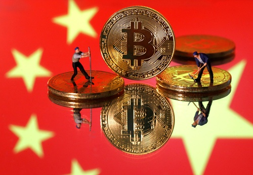 6月25日、暗号資産（仮想通貨）・ビットコインの「マイニング（採掘）」で世界シェアの50％強を占める中国では、政府と金融当局が先月、マイニング禁止の方針を打ち出した。写真はビットコインと中国旗のイメージ。2020年4月撮影（2021年　ロイター/Dado Ruvic）