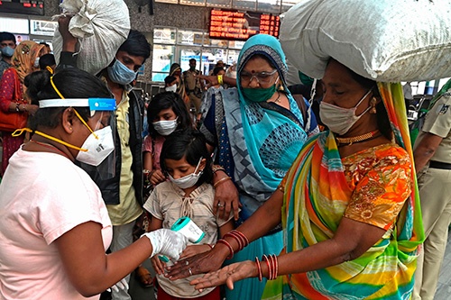 インド西部の都市ムンバイの駅で体温検査を受ける女性。国内の新型コロナ累計感染者数は増え続けているが、移動は活発化している(写真:AFP/アフロ)