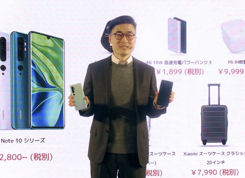 12月9日、日本市場参入の発表会で、1億画素のカメラなどを搭載したスマホを披露する小米のスティーブン・ワン氏（写真：共同通信）