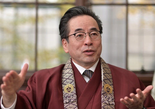 <span class="fontBold">やすなが・ゆうげん</span><br> 1954年東京都生まれ。慶應義塾大学経済学部卒業。英ケンブリッジ大学大学院経営学専攻博士課程修了。三和銀行(現三菱UFJ銀行)に21年間勤務後、米人材紹介会社ラッセル・レイノルズを経て独立。2006年経営幹部人材紹介・コンサルティングの島本パートナーズ社長。15年7月築地本願寺代表役員・宗務長に就任。法務に従事するとともに寺院運営管理や伝導布教活動を推進する(写真/菊池一郎)