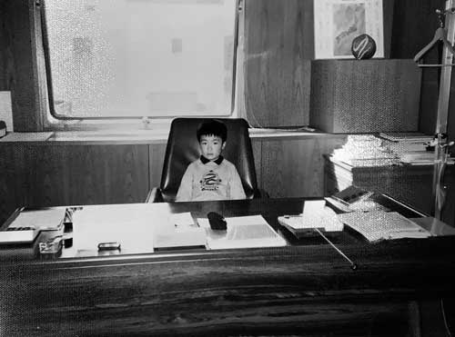 幼少時の岡田高幸氏。当時、たち吉の社長だった祖父に「社長の椅子」に座らされて記念撮影