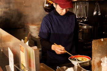厨房で腕を振るう、本店「ソラノイロ japanese soup noodle free style」副店長の塩田剛基氏